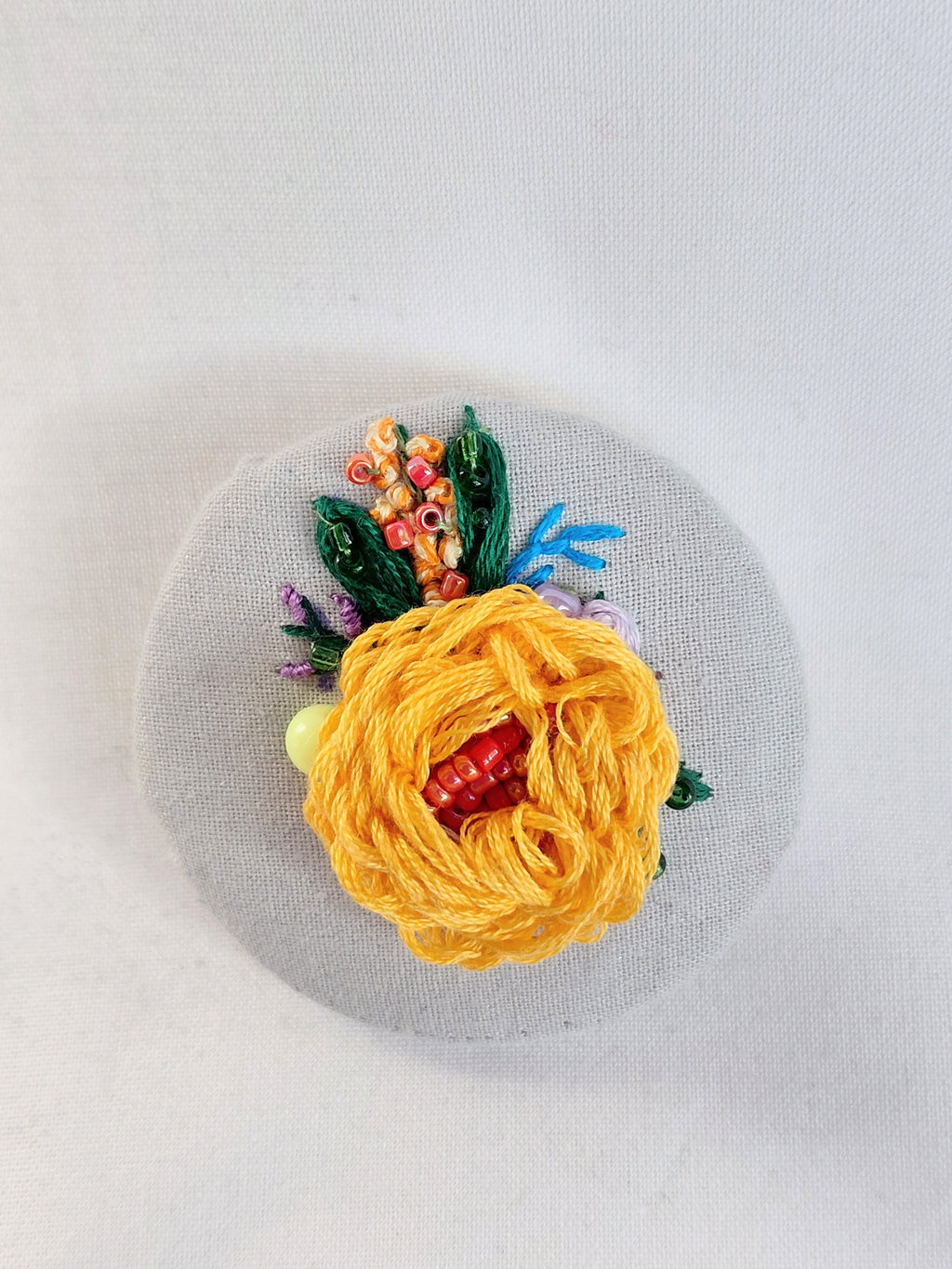 Decorative orange flower brooch on grey spec background