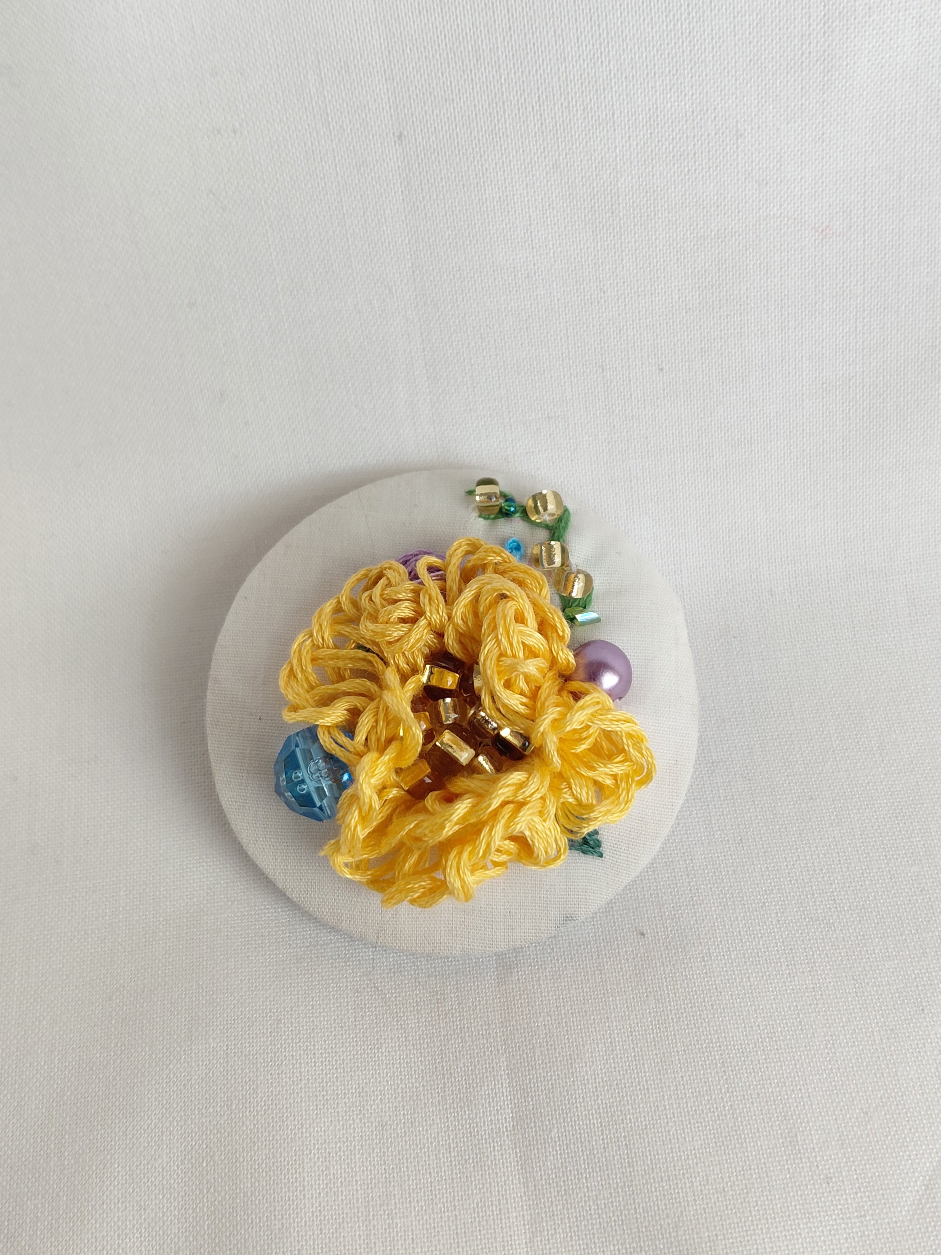 Decorative orange flower brooch on white background