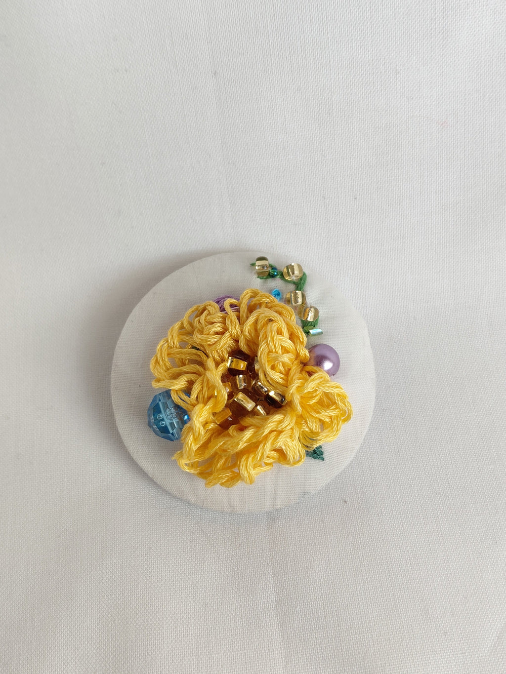 Decorative orange flower brooch on white background