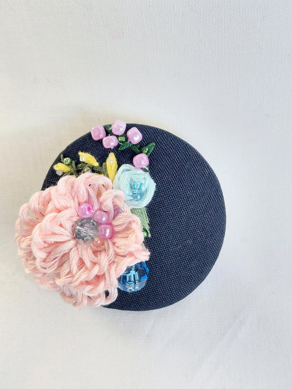 Decorative pink flower brooch on black background