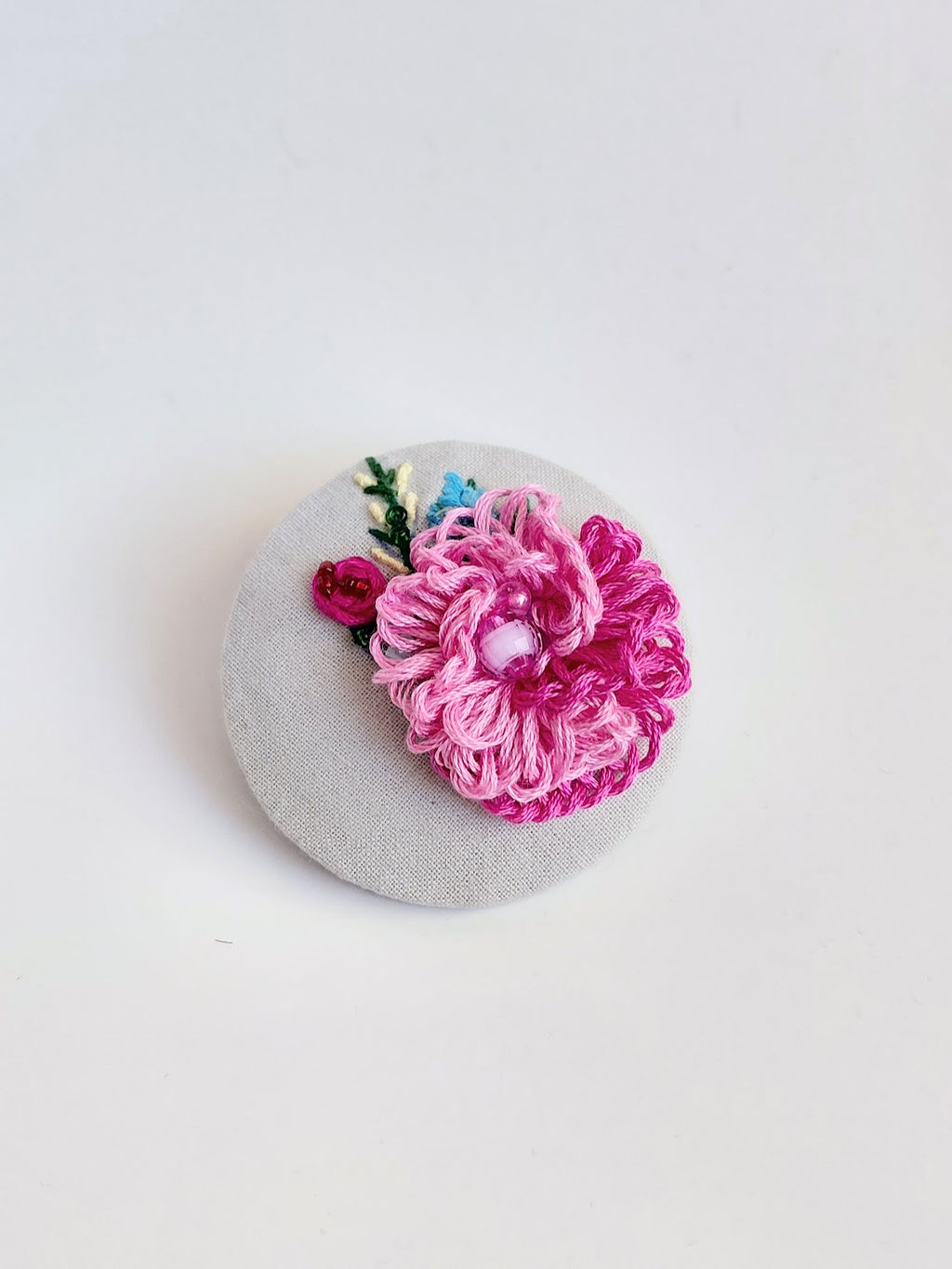 Decorative pink flower brooch on grey background
