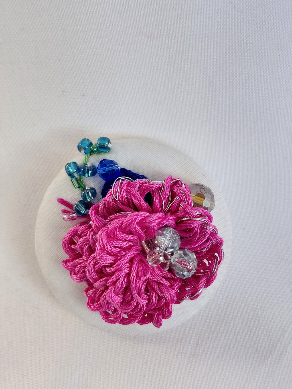Decorative fuschia flower brooch on white background