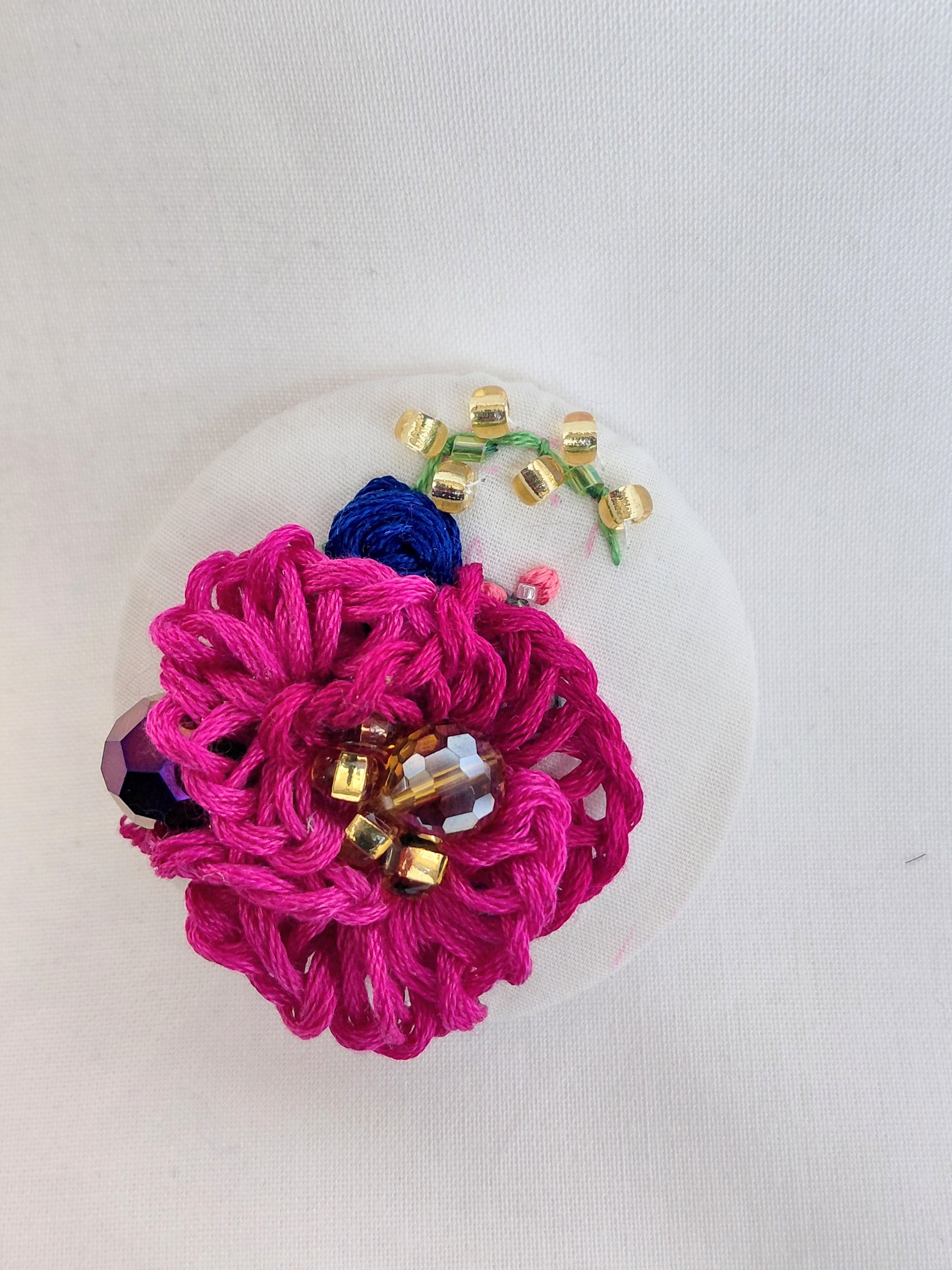 Decorative fuschia flower brooch on white background