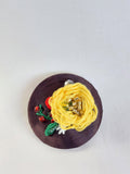 Decorative yellow flower brooch on brown background