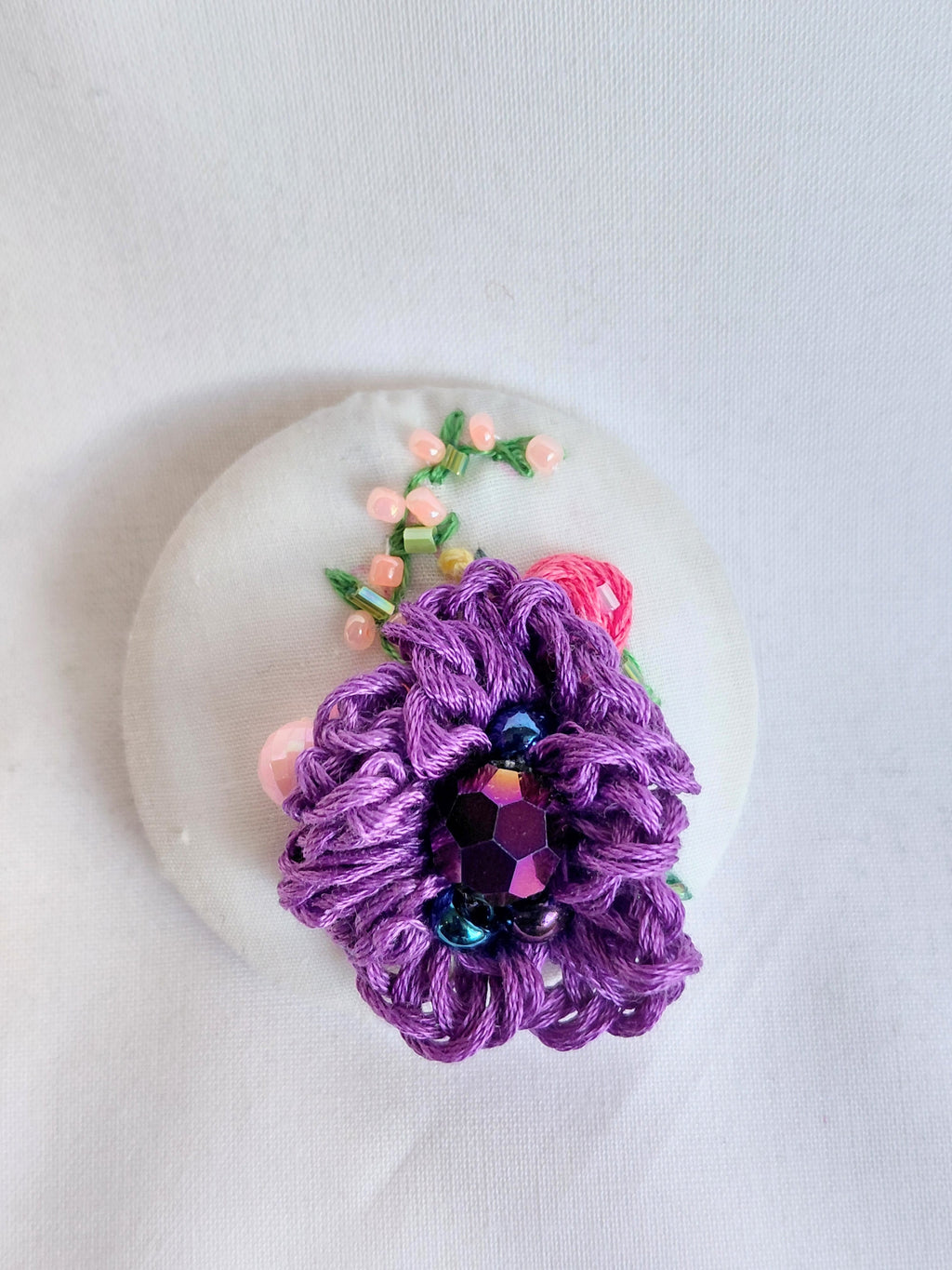 Decorative purple flower brooch on white background