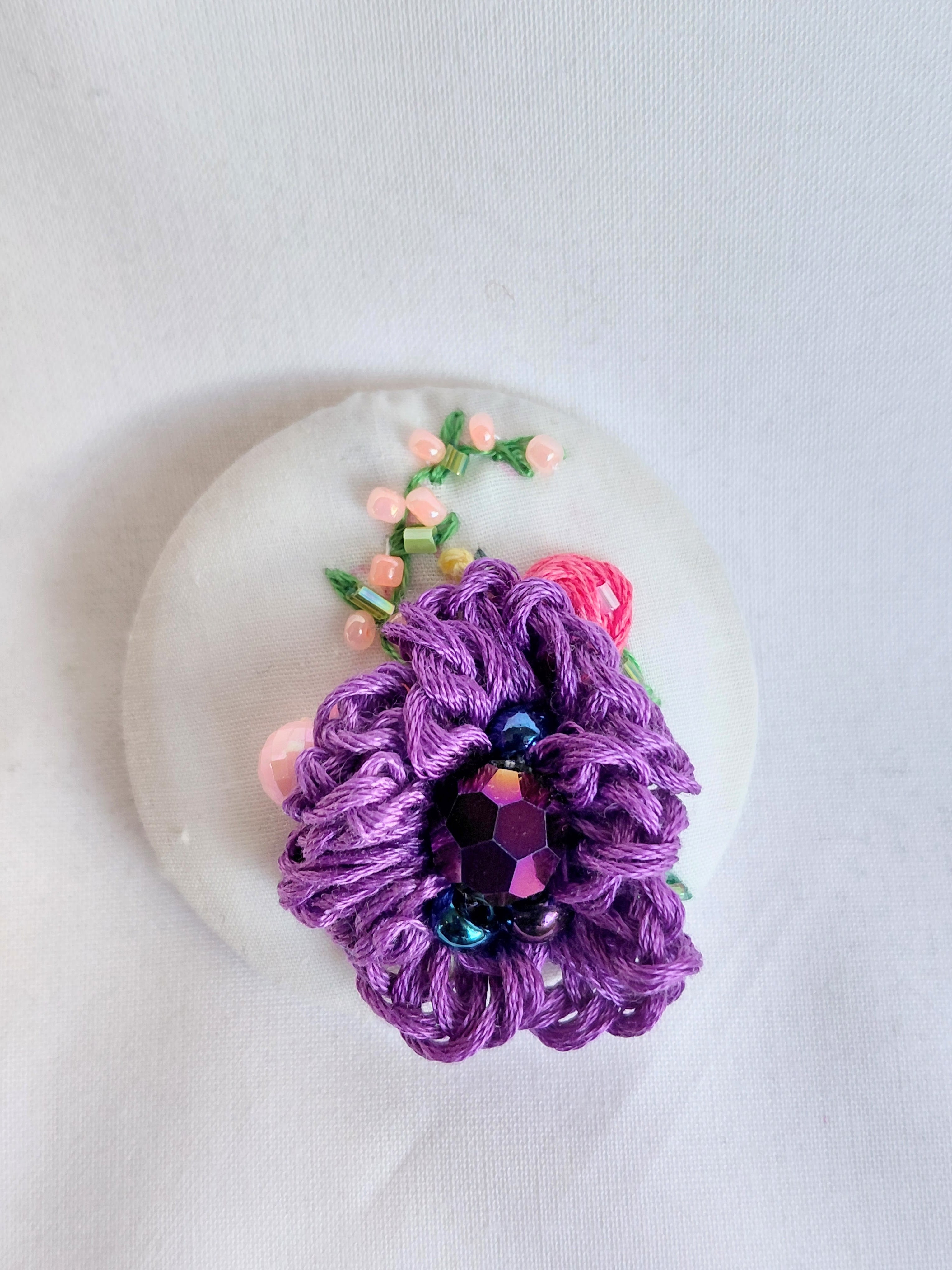Decorative purple flower brooch on white background