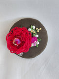 Decorative red flower brooch on olive background