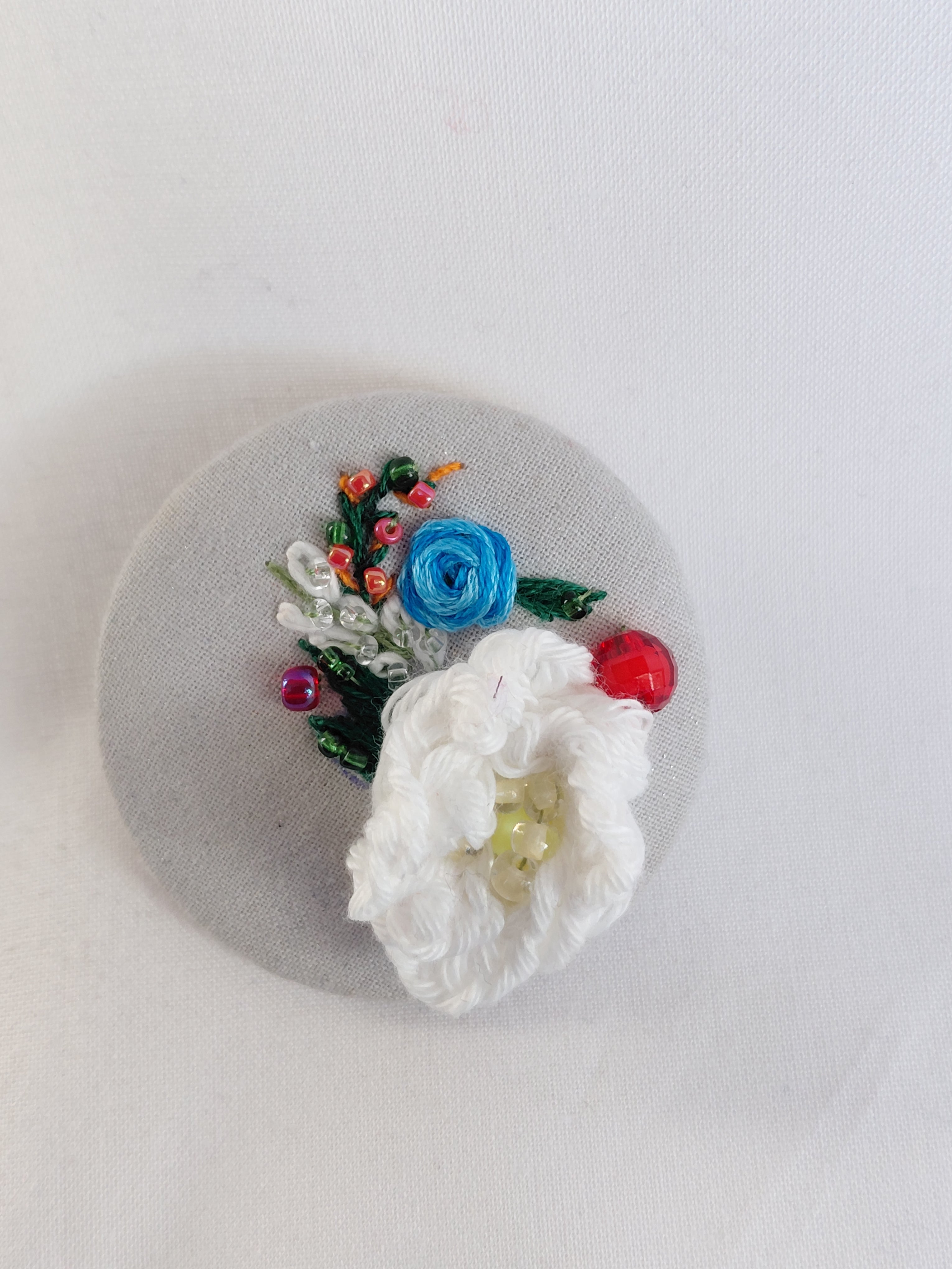 Decorative white flower brooch on grey spec background