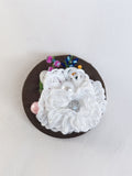 Decorative white flower brooch on olive background