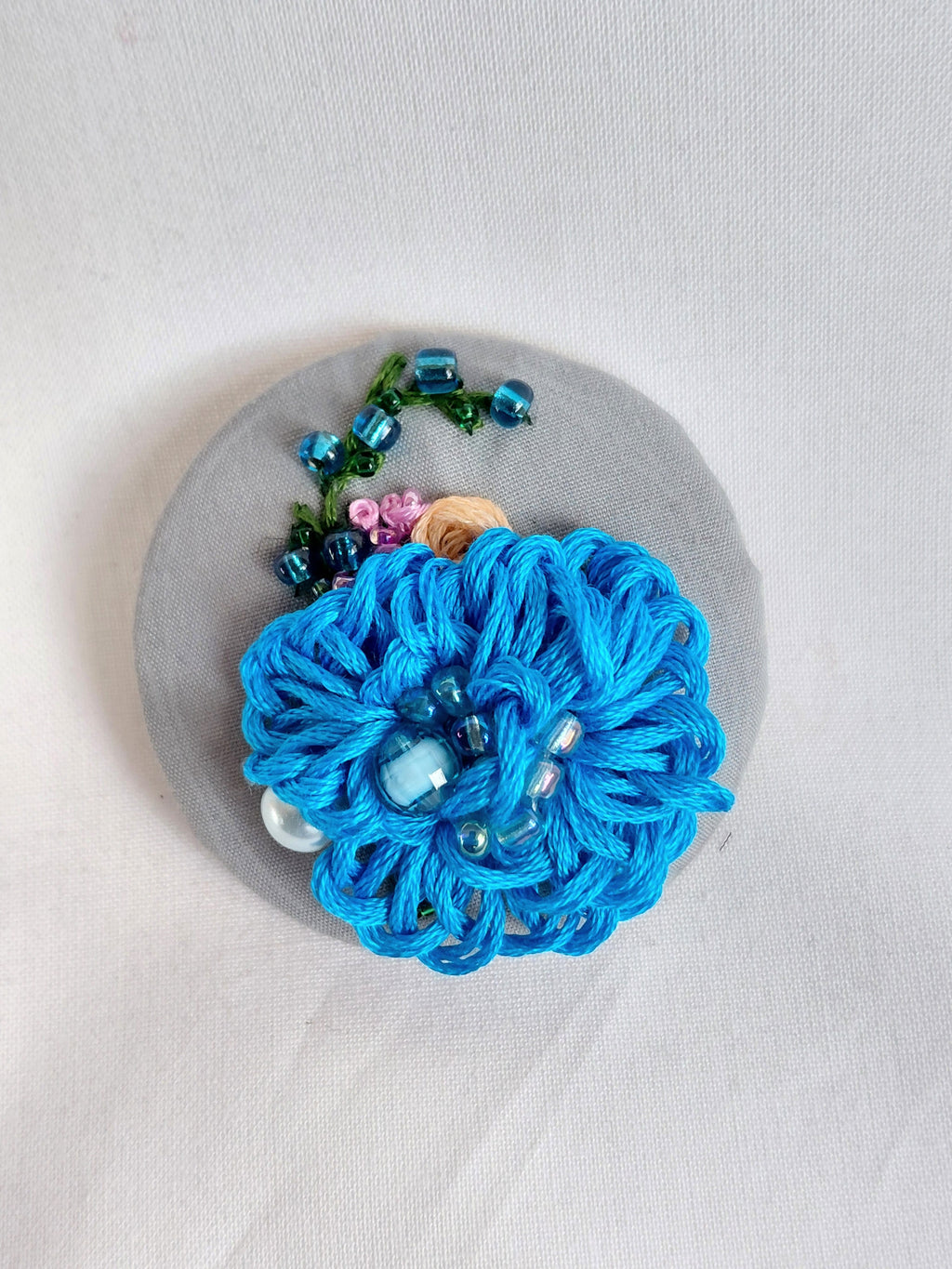 Decorative blue flower brooch on grey  background