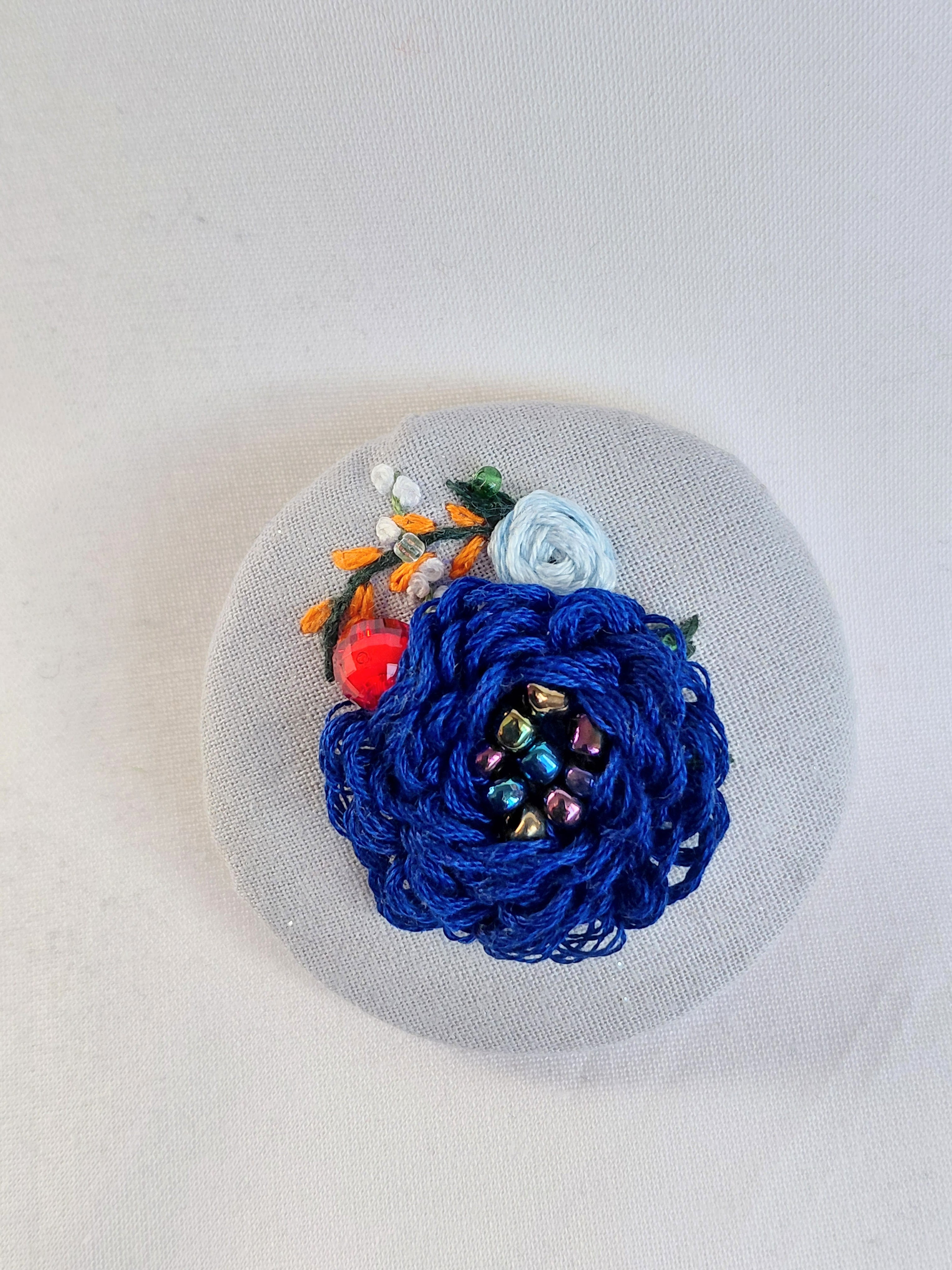 Decorative blue flower brooch on blue spec background