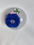 Decorative blue flower brooch on grey background