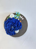 Decorative blue flower brooch on olive background