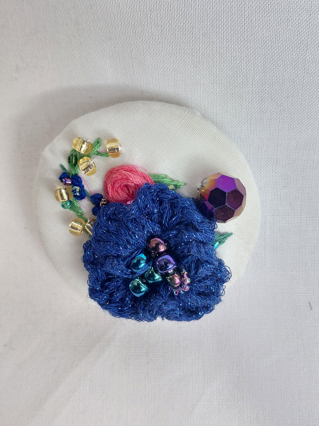 Decorative blue flower brooch on white background