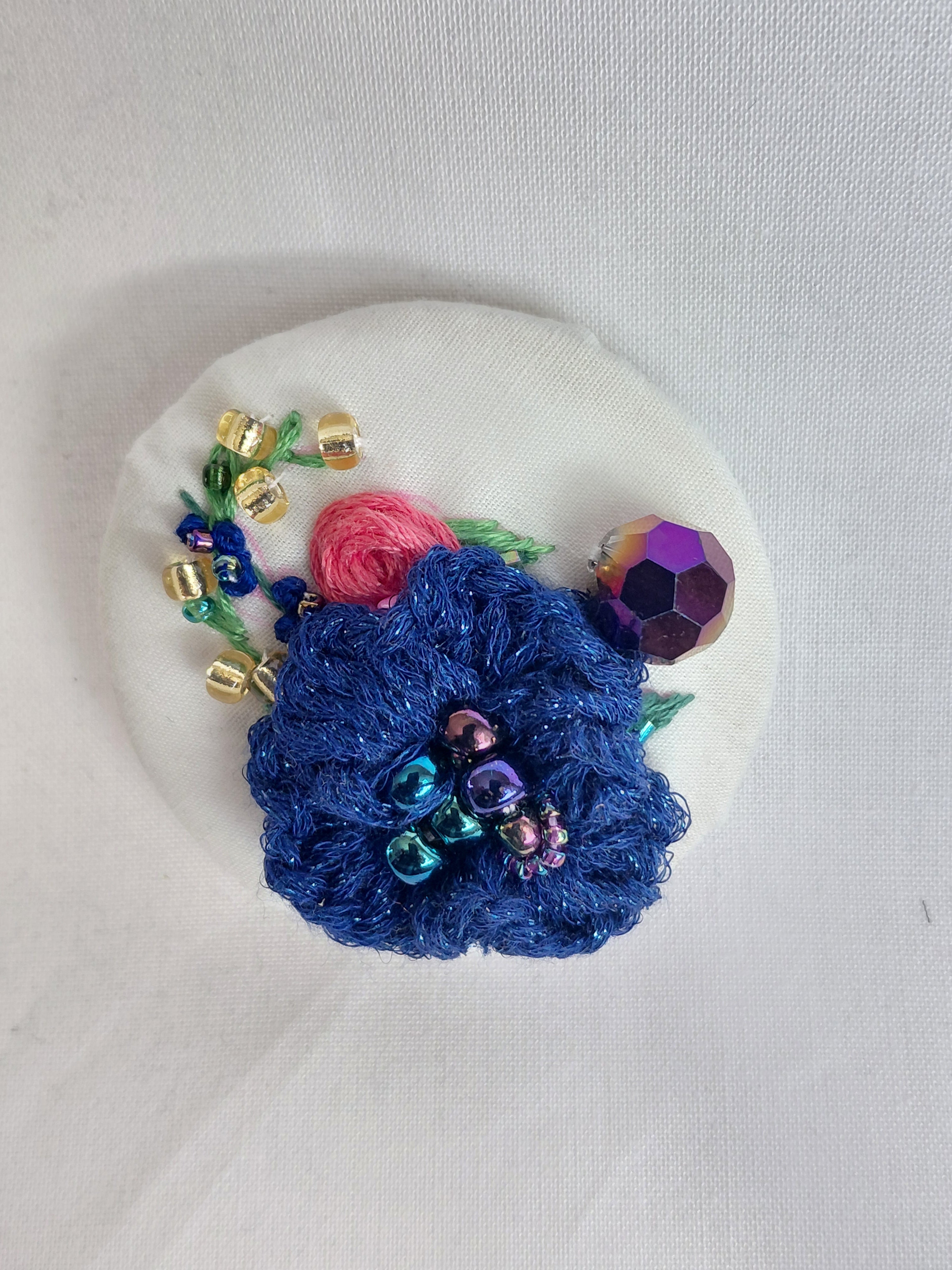Decorative blue flower brooch on white background