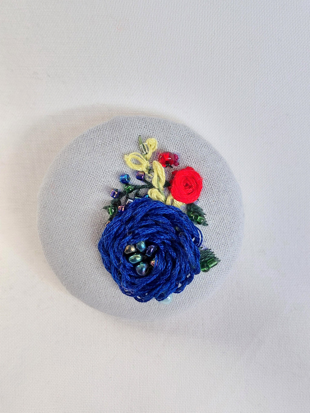 Decorative blue flower brooch on blue spec background