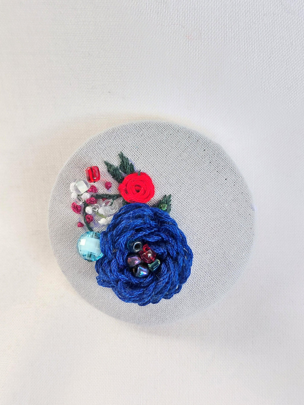 Decorative blue flower brooch on blue spec background