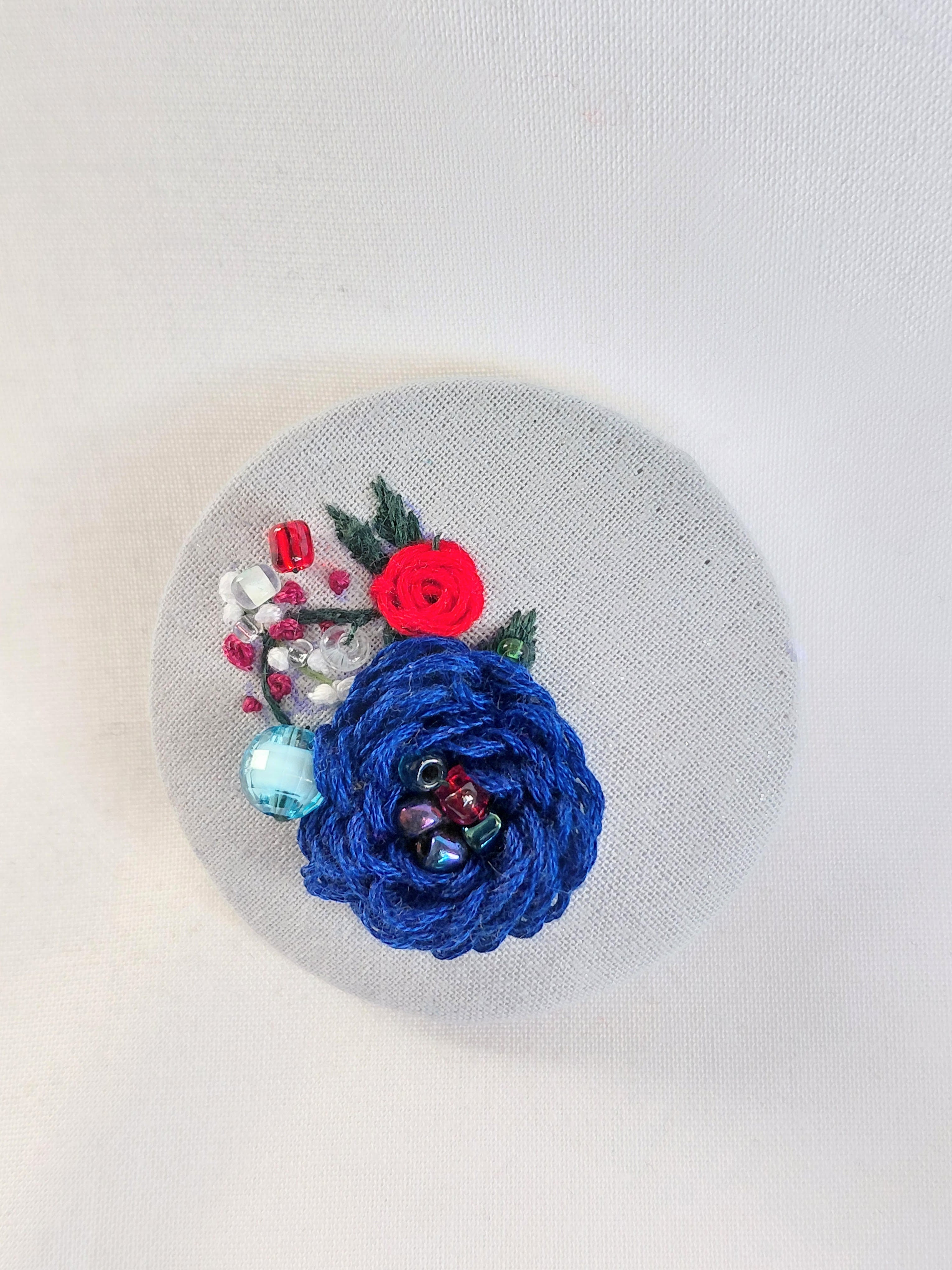 Decorative blue flower brooch on blue spec background