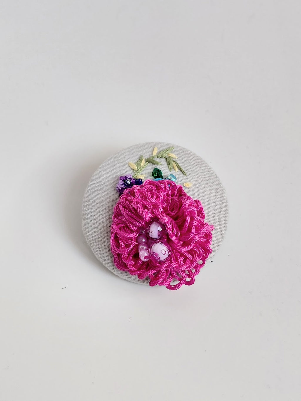 Decorative pink flower brooch on grey background