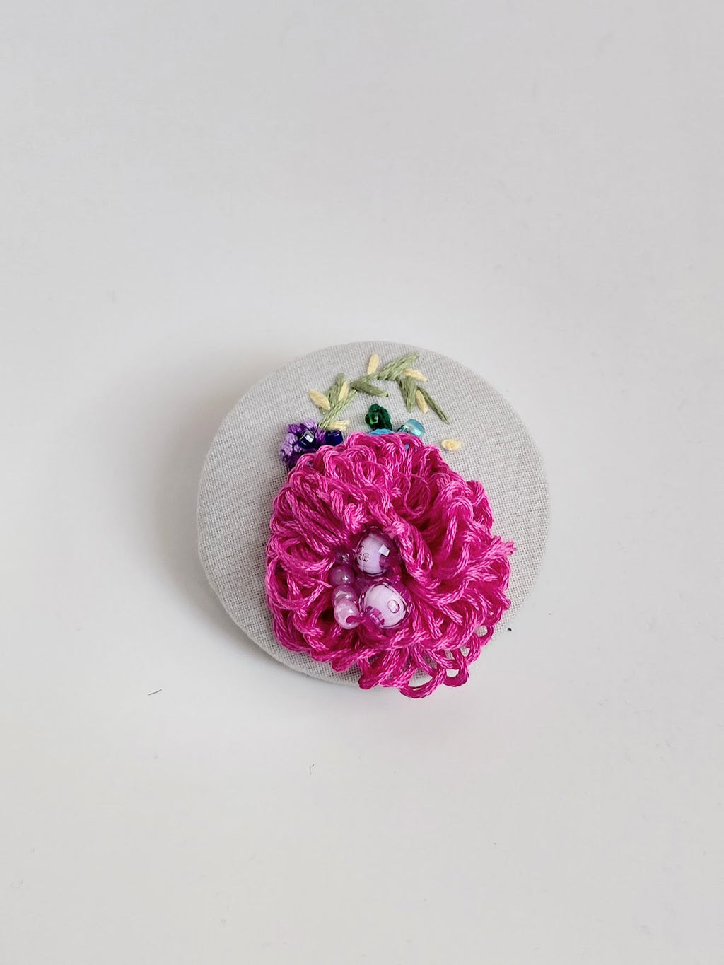 Decorative pink flower brooch on grey background
