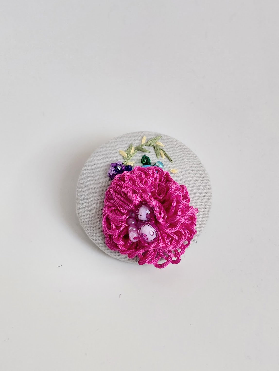 Decorative pink flower brooch on grey background