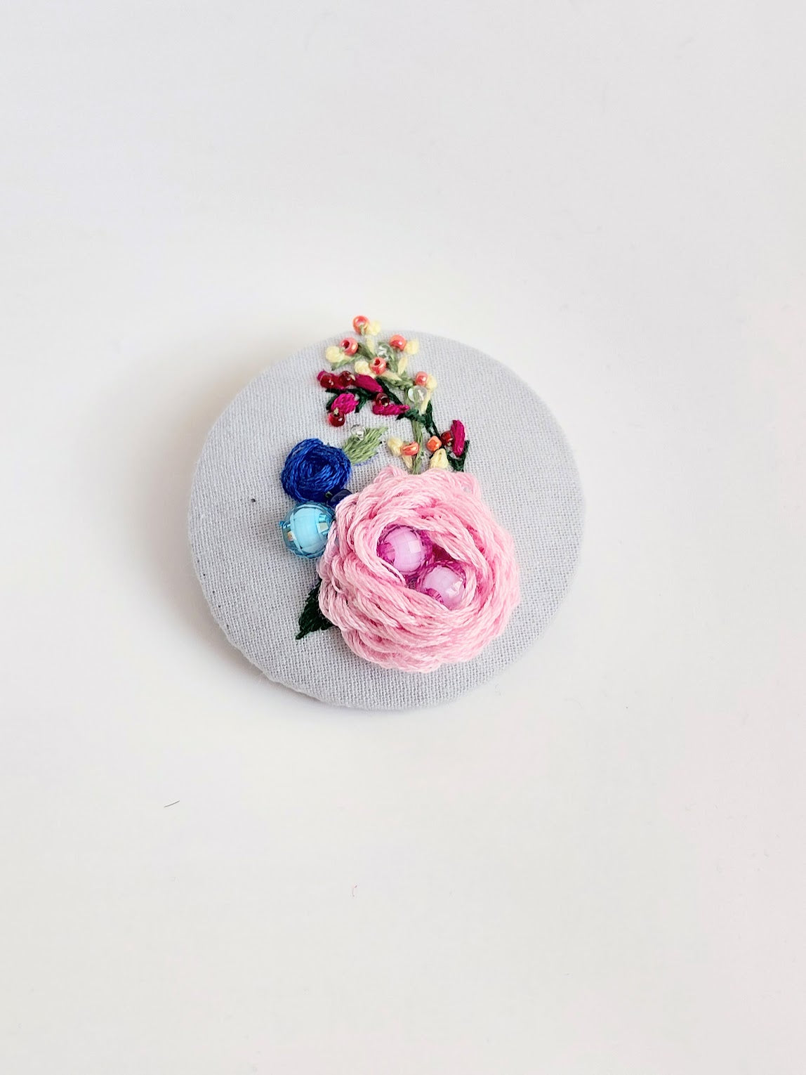Decorative pink flower brooch on grey background