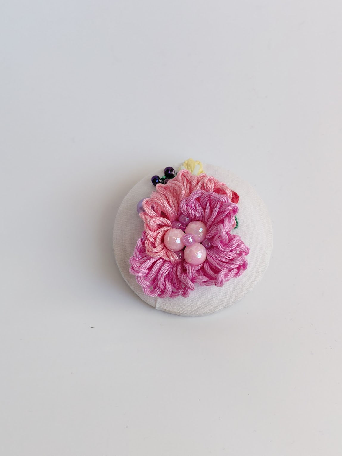 Decorative pink flower brooch on white background