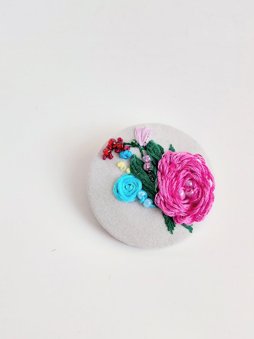 Decorative pink flower brooch on grey background