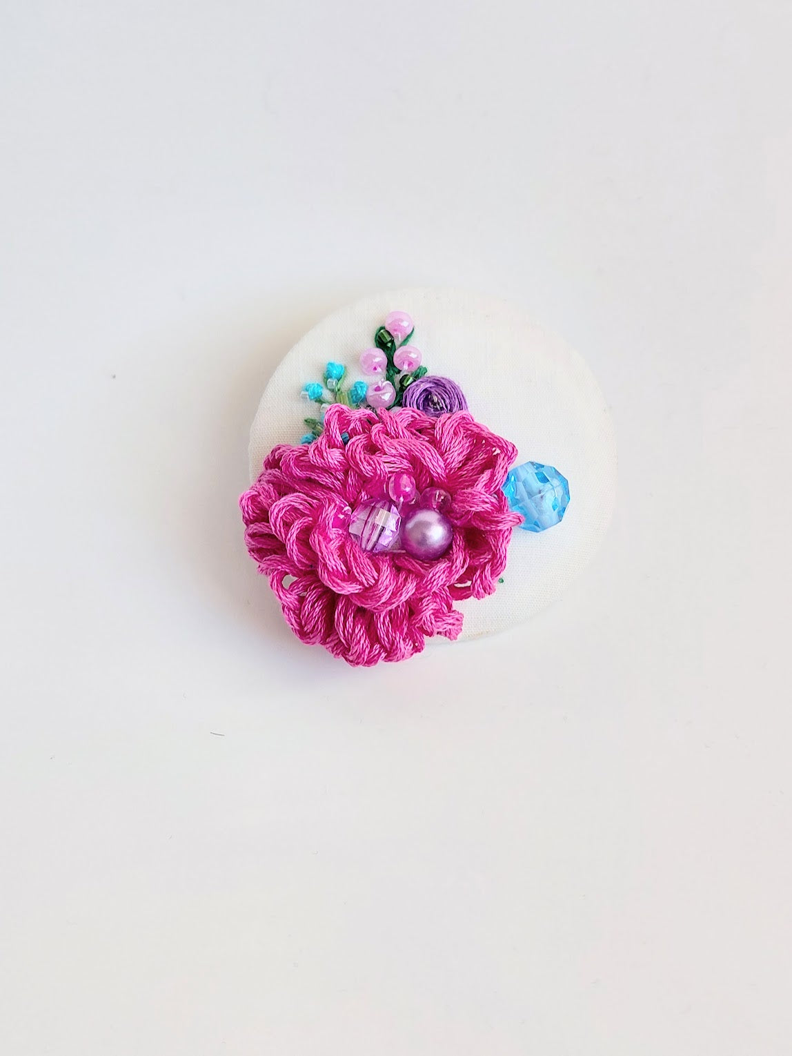 Decorative pink flower brooch on white background