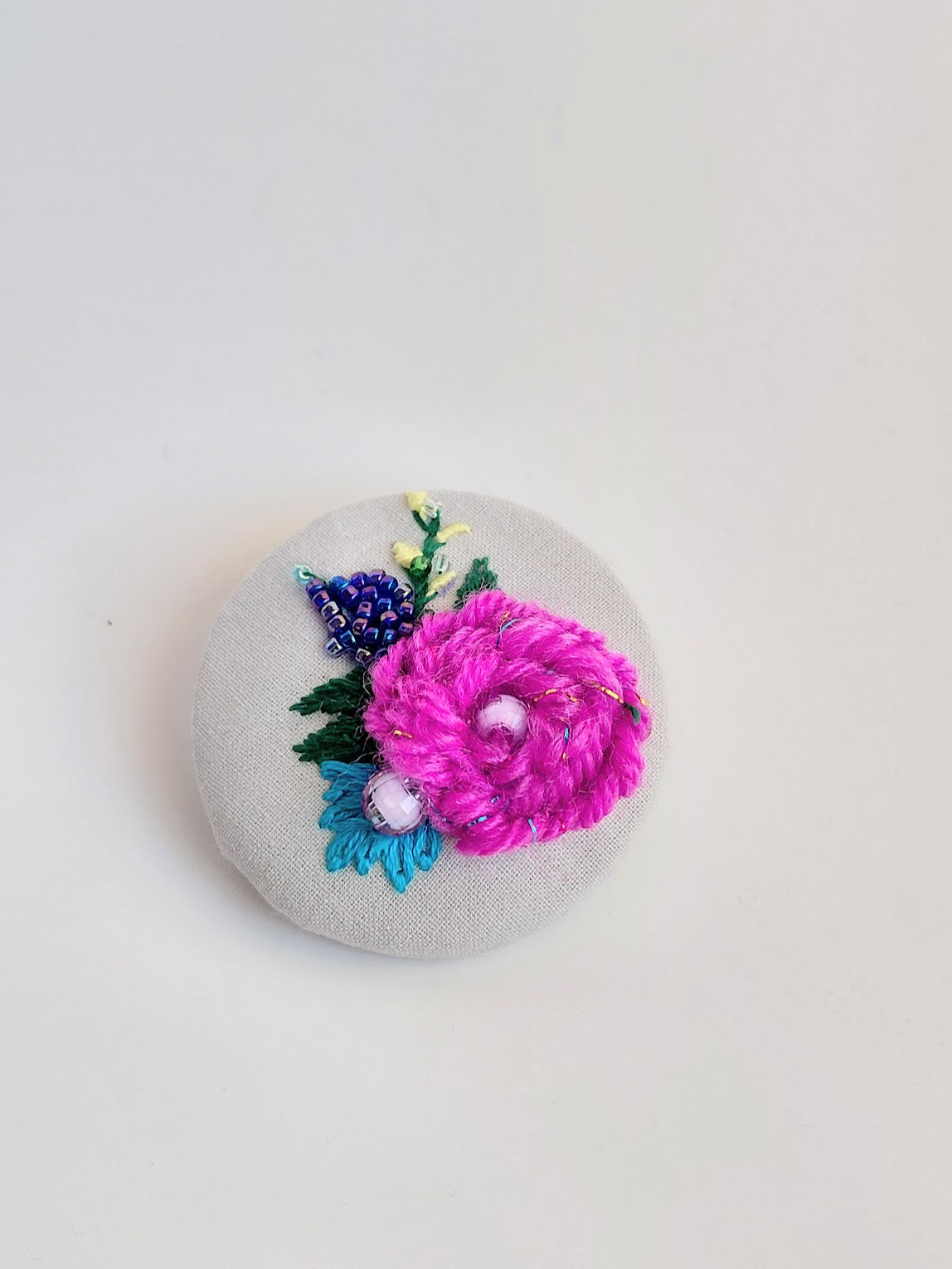 Decorative fuschia flower brooch on grey background