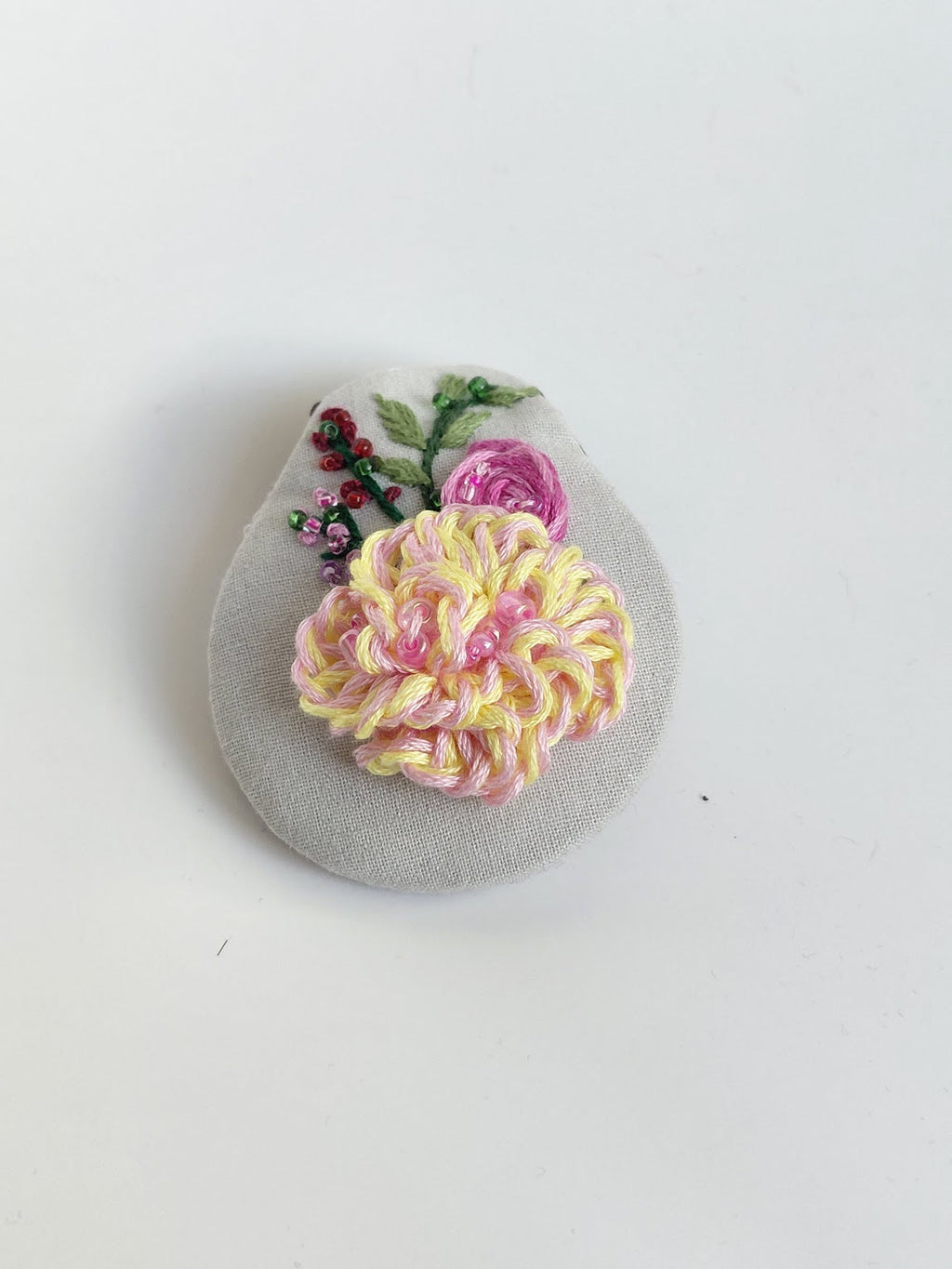 Decorative fuschia flower brooch on grey background