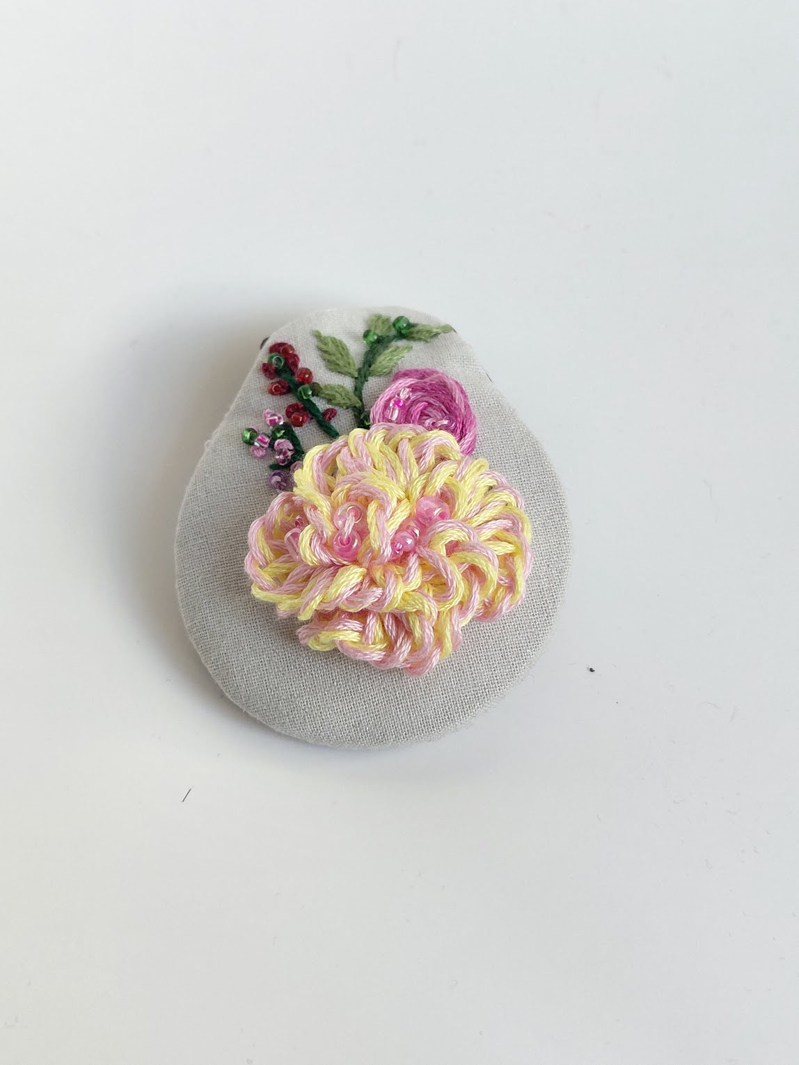 Decorative fuschia flower brooch on grey background