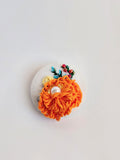Decorative orange flower brooch on white background