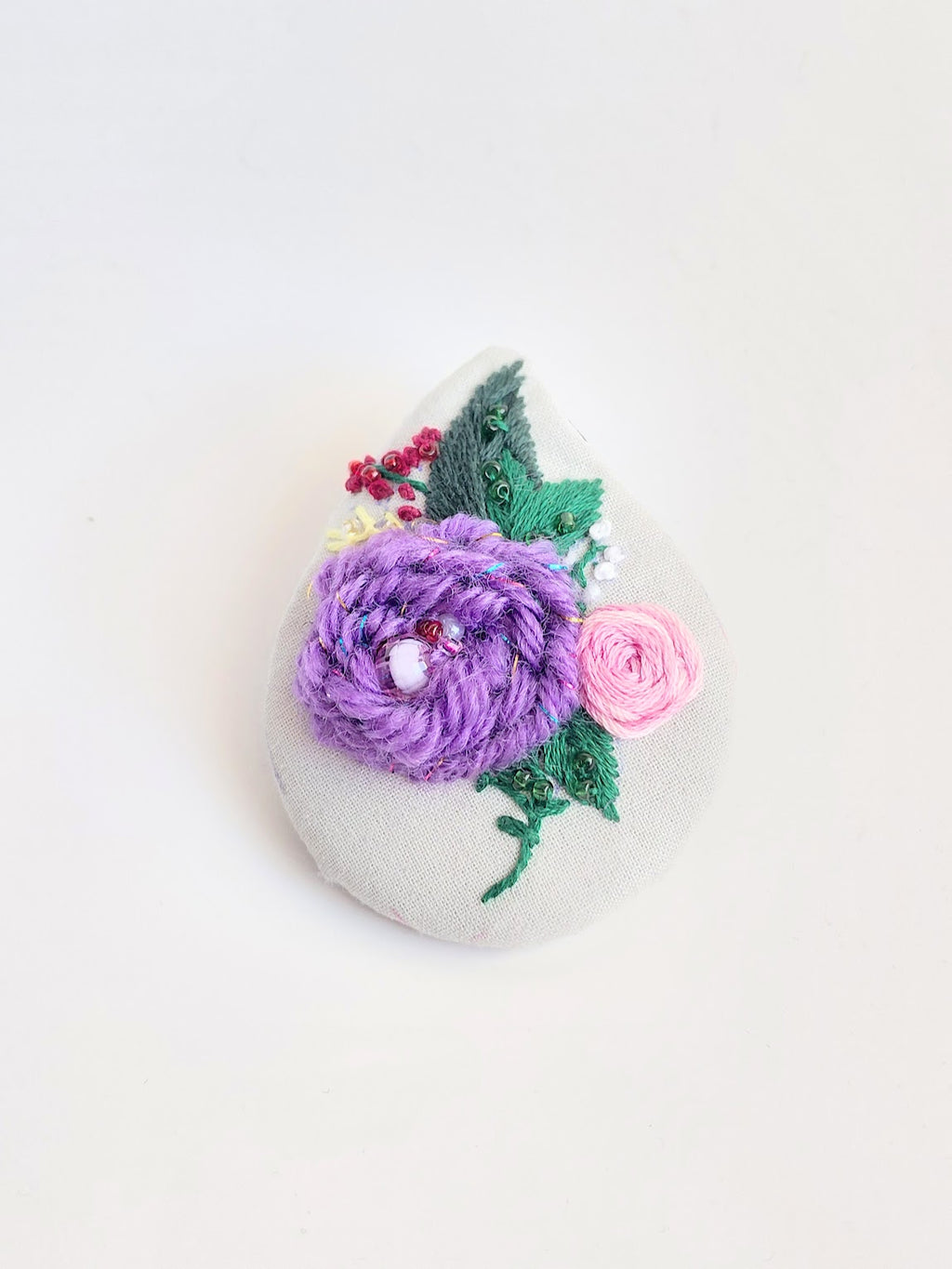 Decorative purple flower brooch on grey background