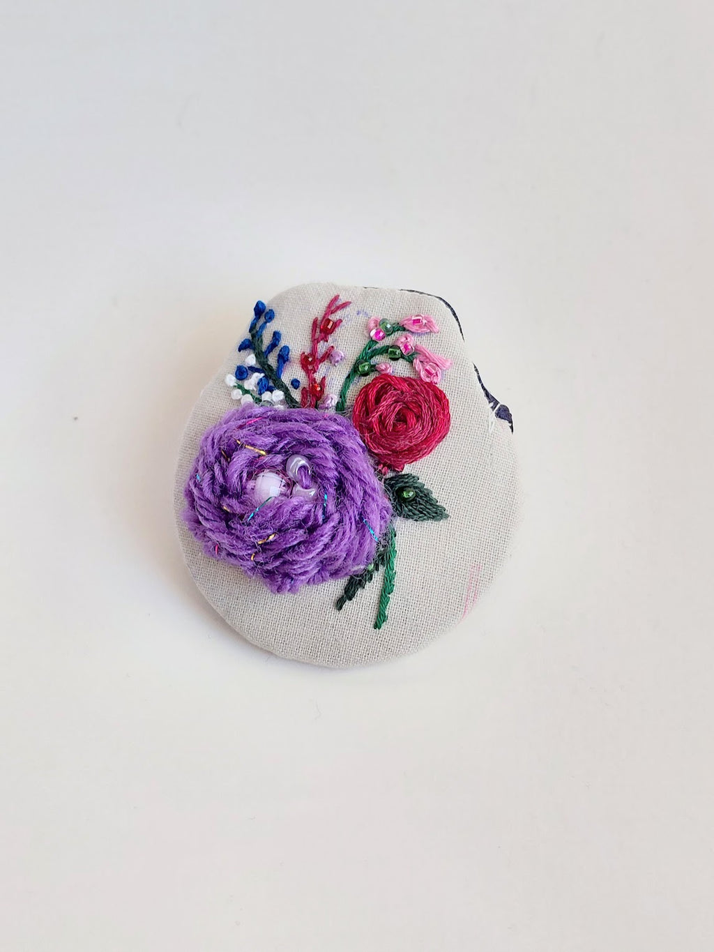 Decorative purple flower brooch on grey background