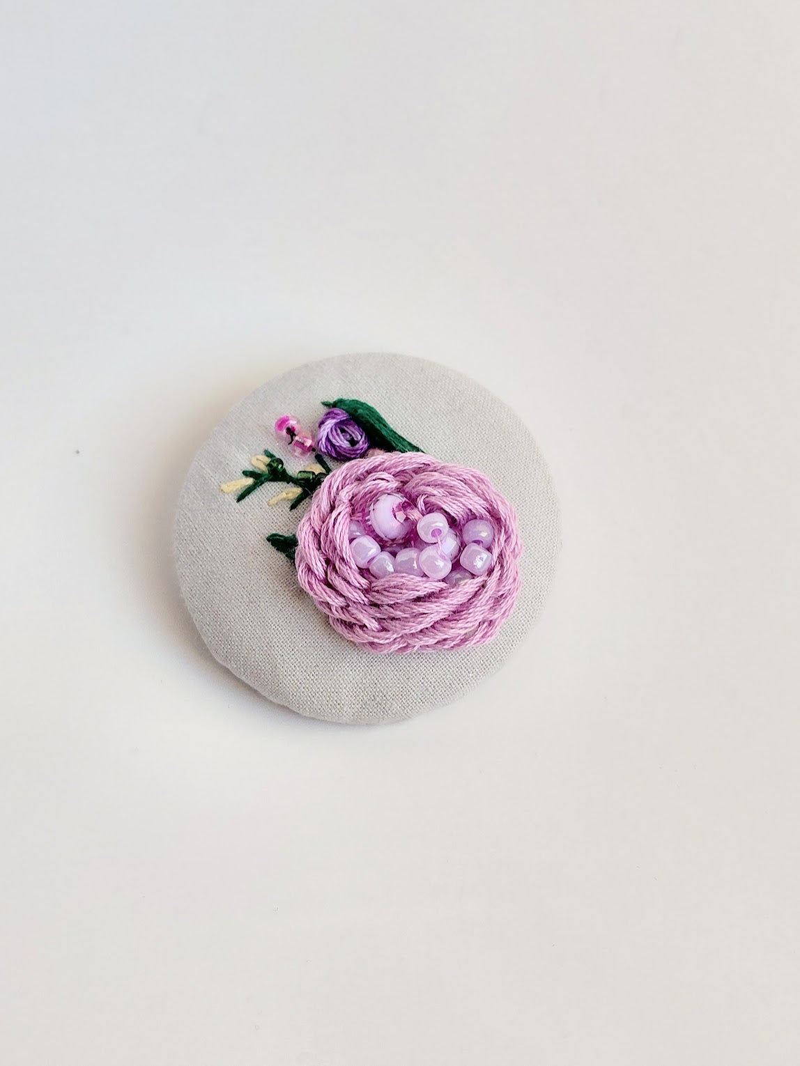 Decorative purple flower brooch on grey background
