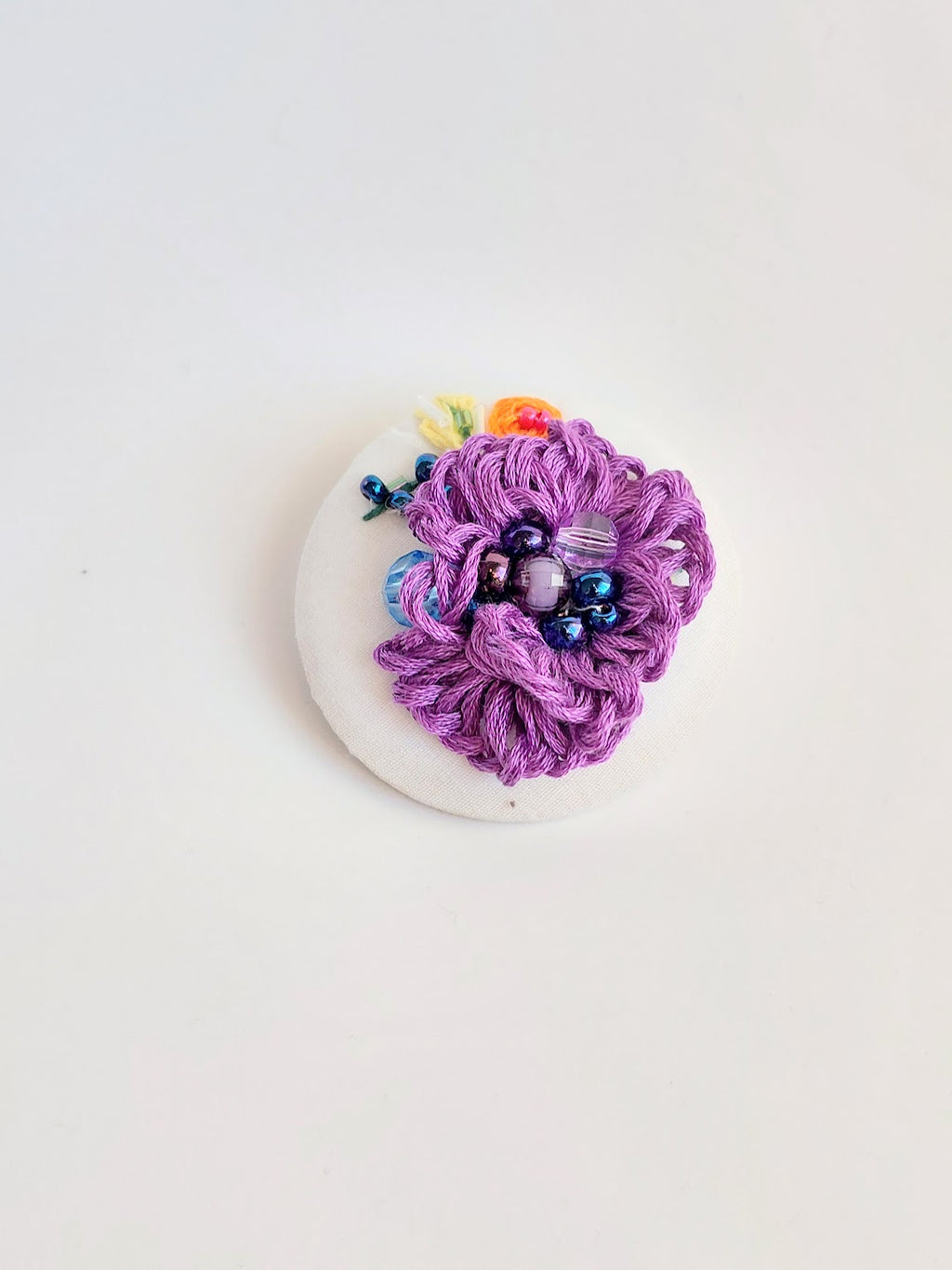 Decorative purple flower brooch on white background