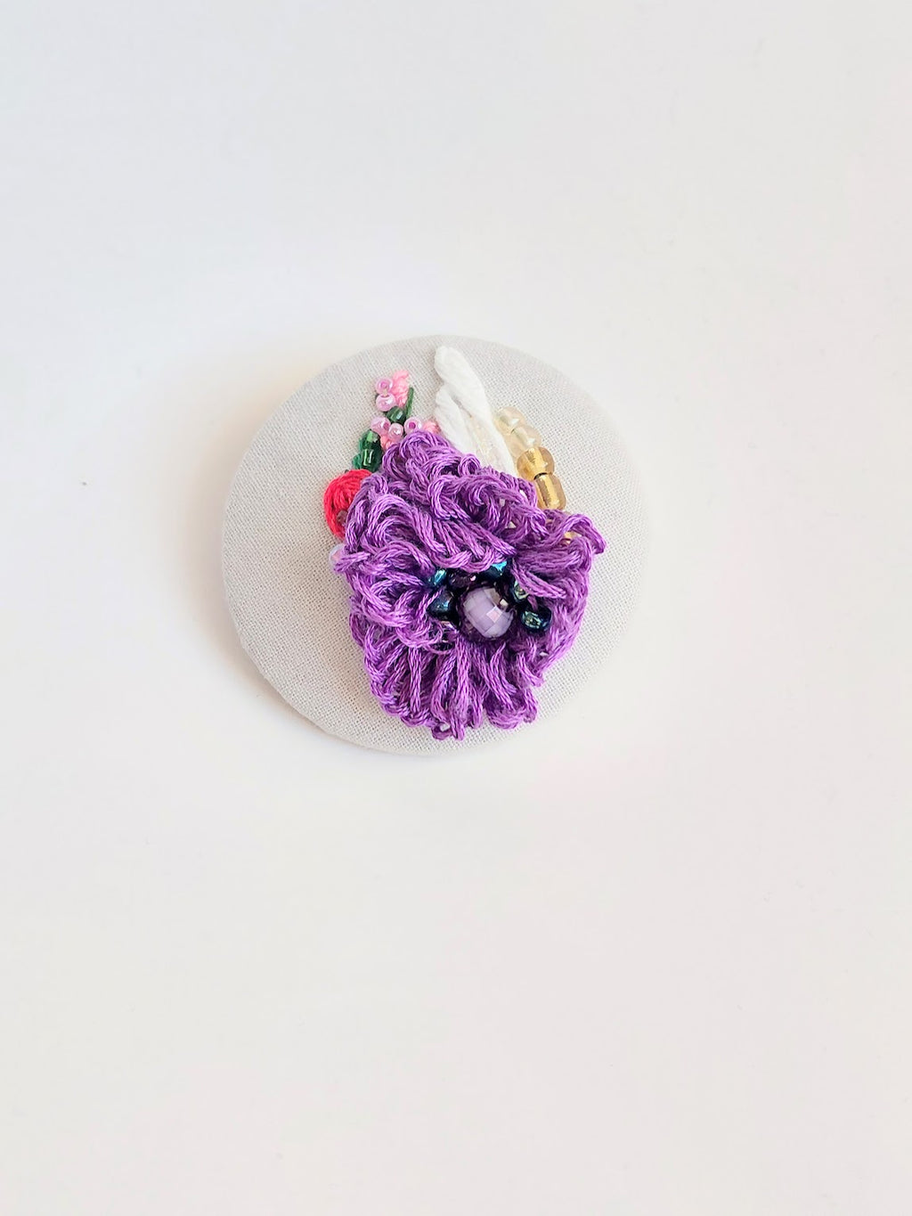 Decorative purple flower brooch on grey background