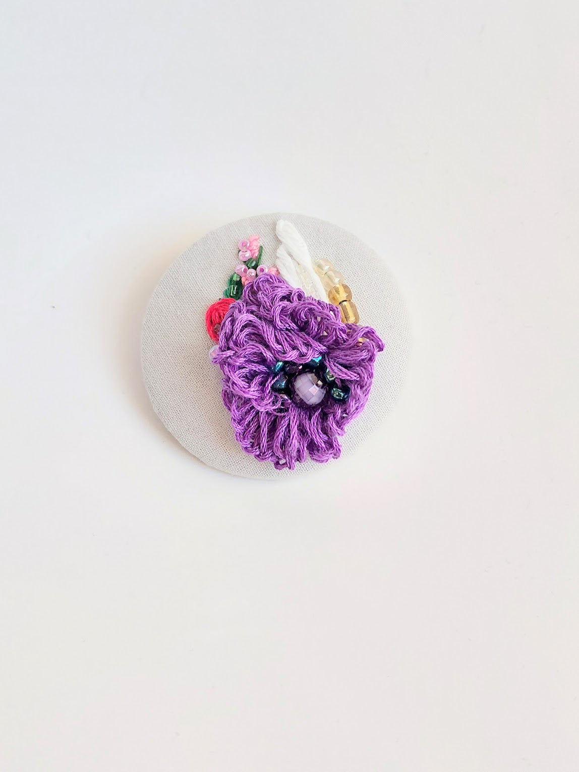 Decorative purple flower brooch on grey background