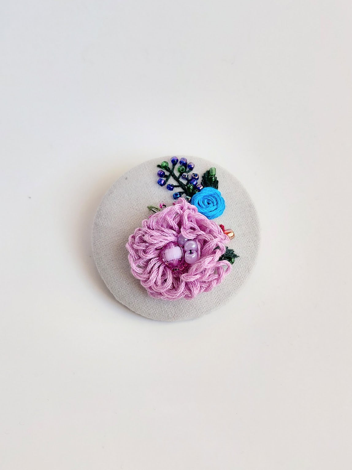 Decorative purple flower brooch on grey background