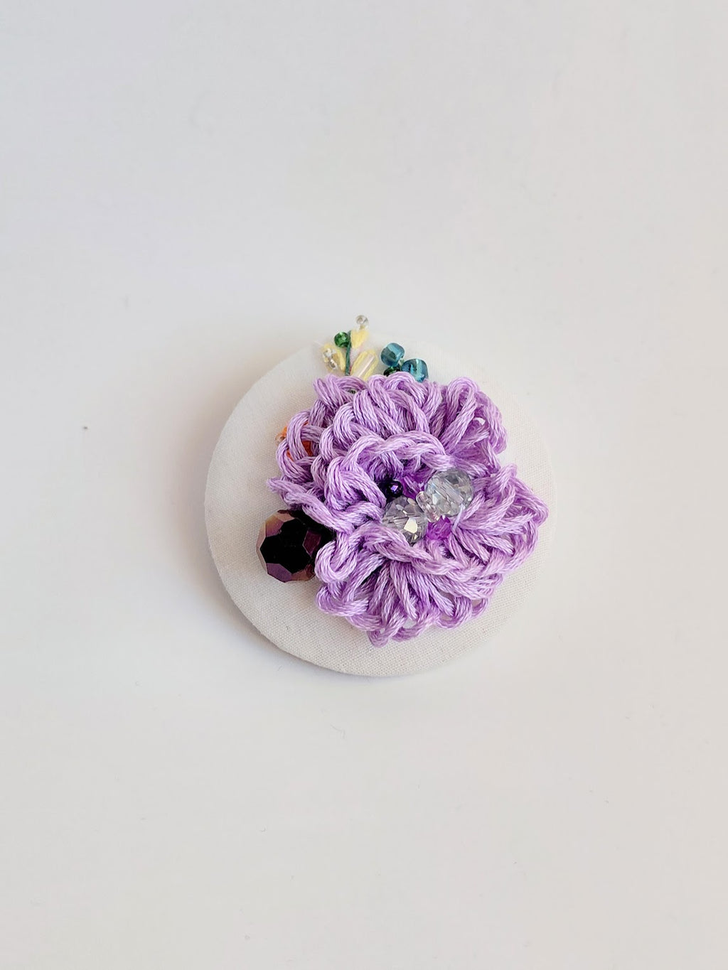 Decorative purple flower brooch on white background