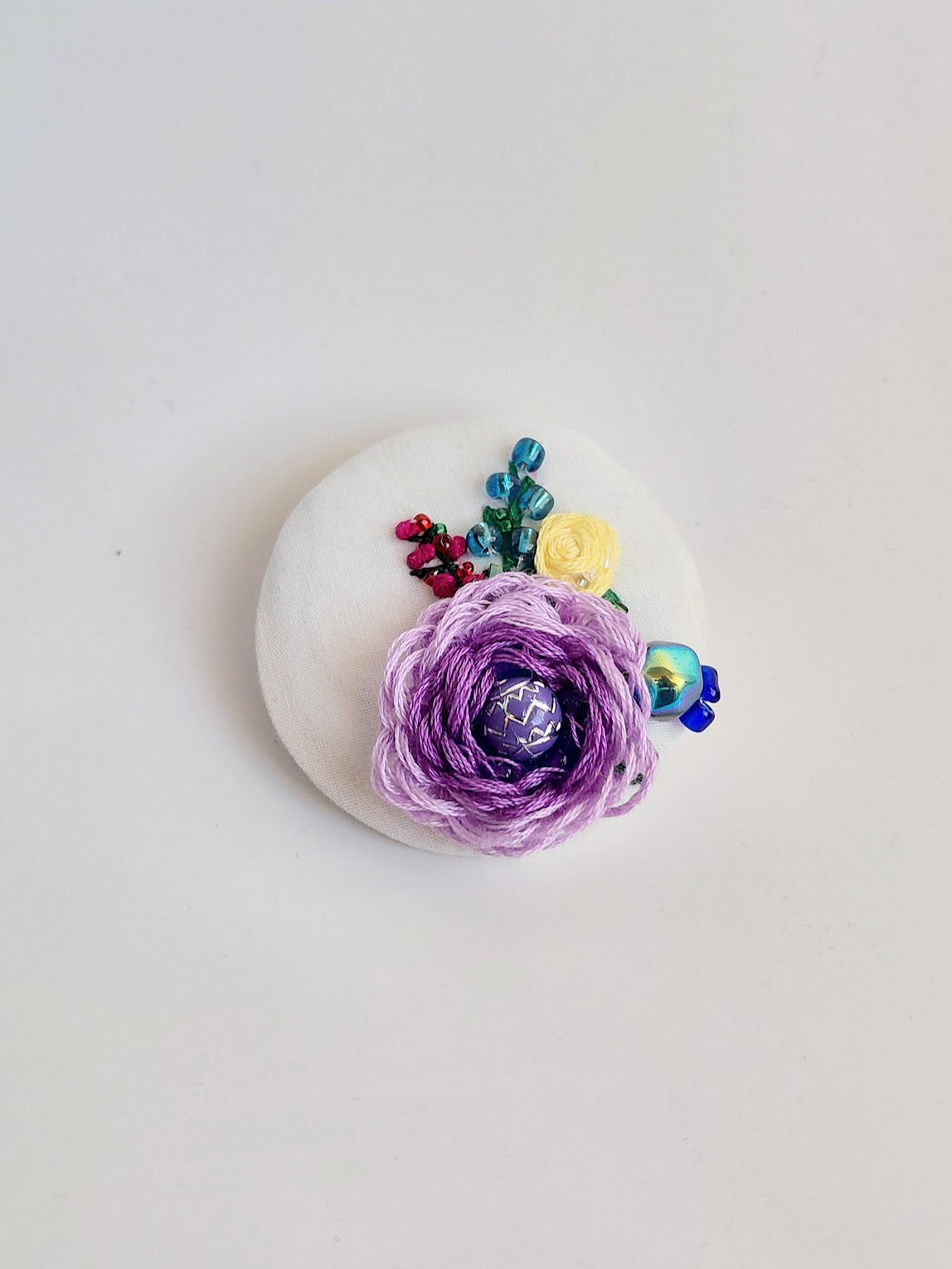 Decorative purple flower brooch on white background