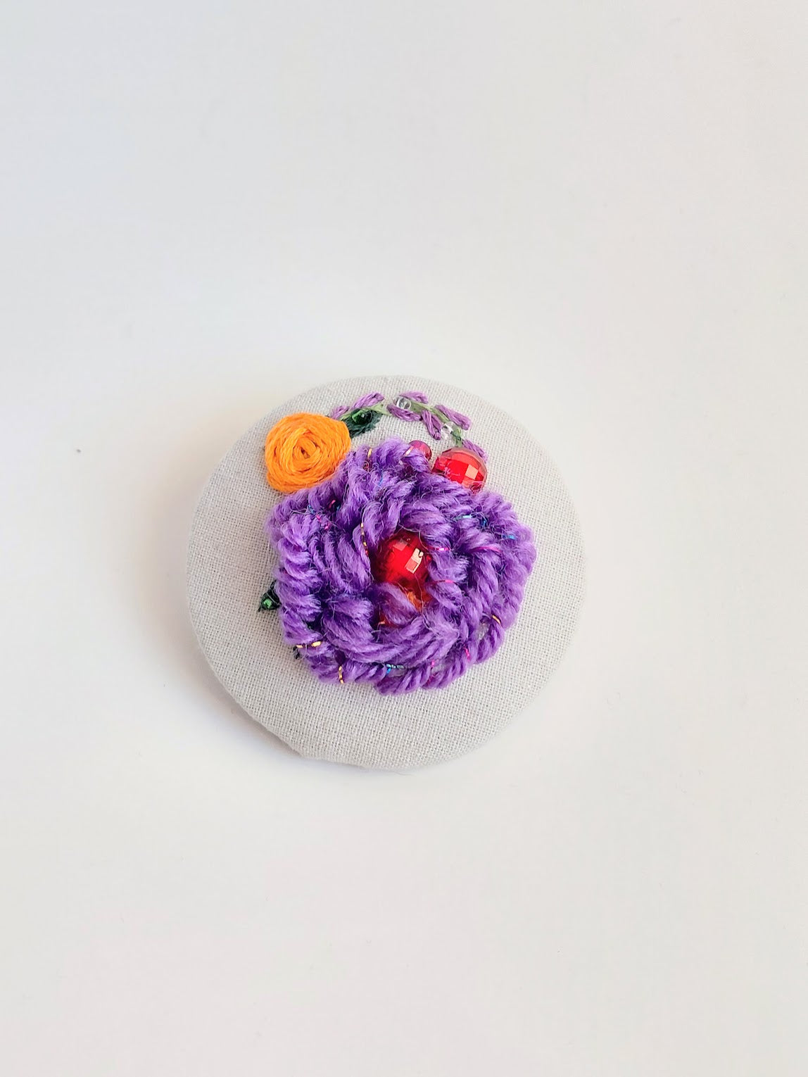 Decorative purple flower brooch on grey background