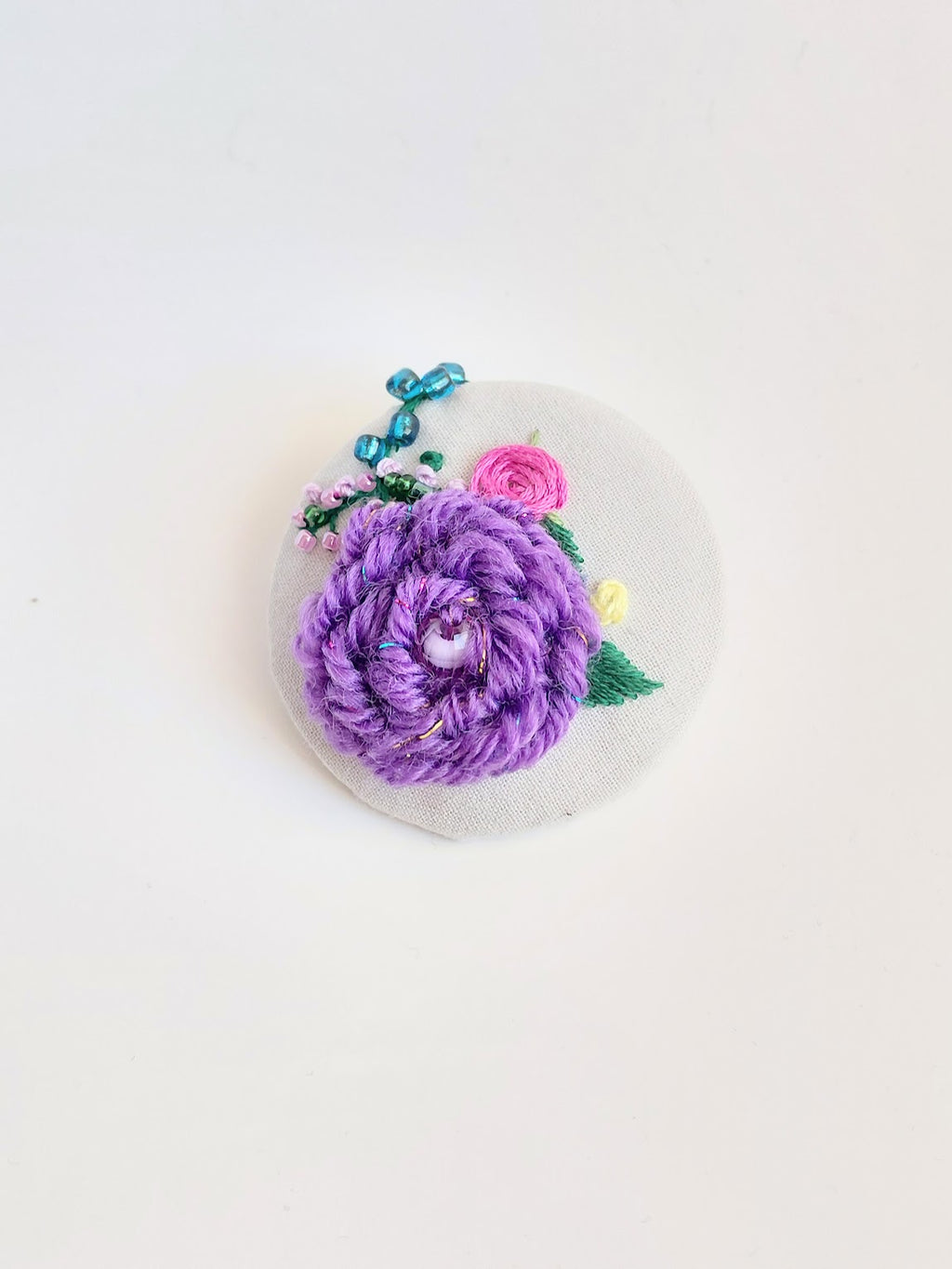 Decorative purple flower brooch on grey background