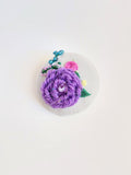 Decorative purple flower brooch on grey background