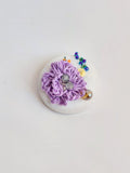 Decorative purple flower brooch on white background