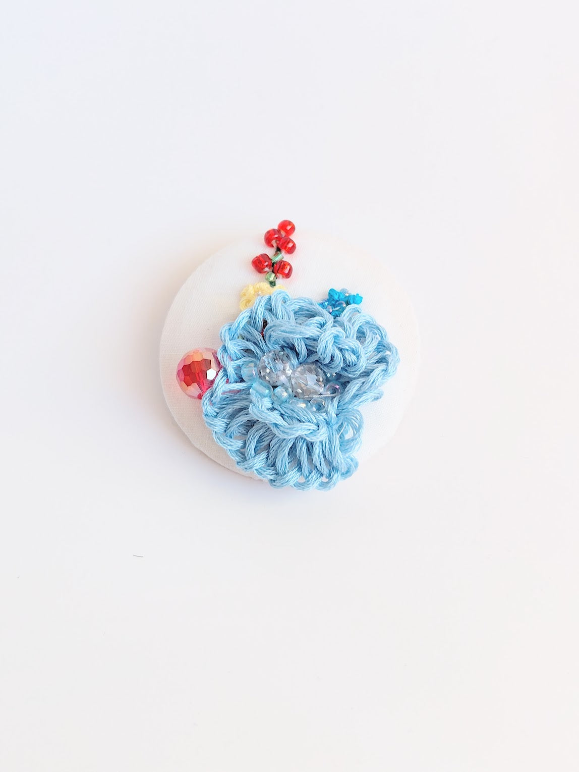 Decorative blue flower brooch on white background