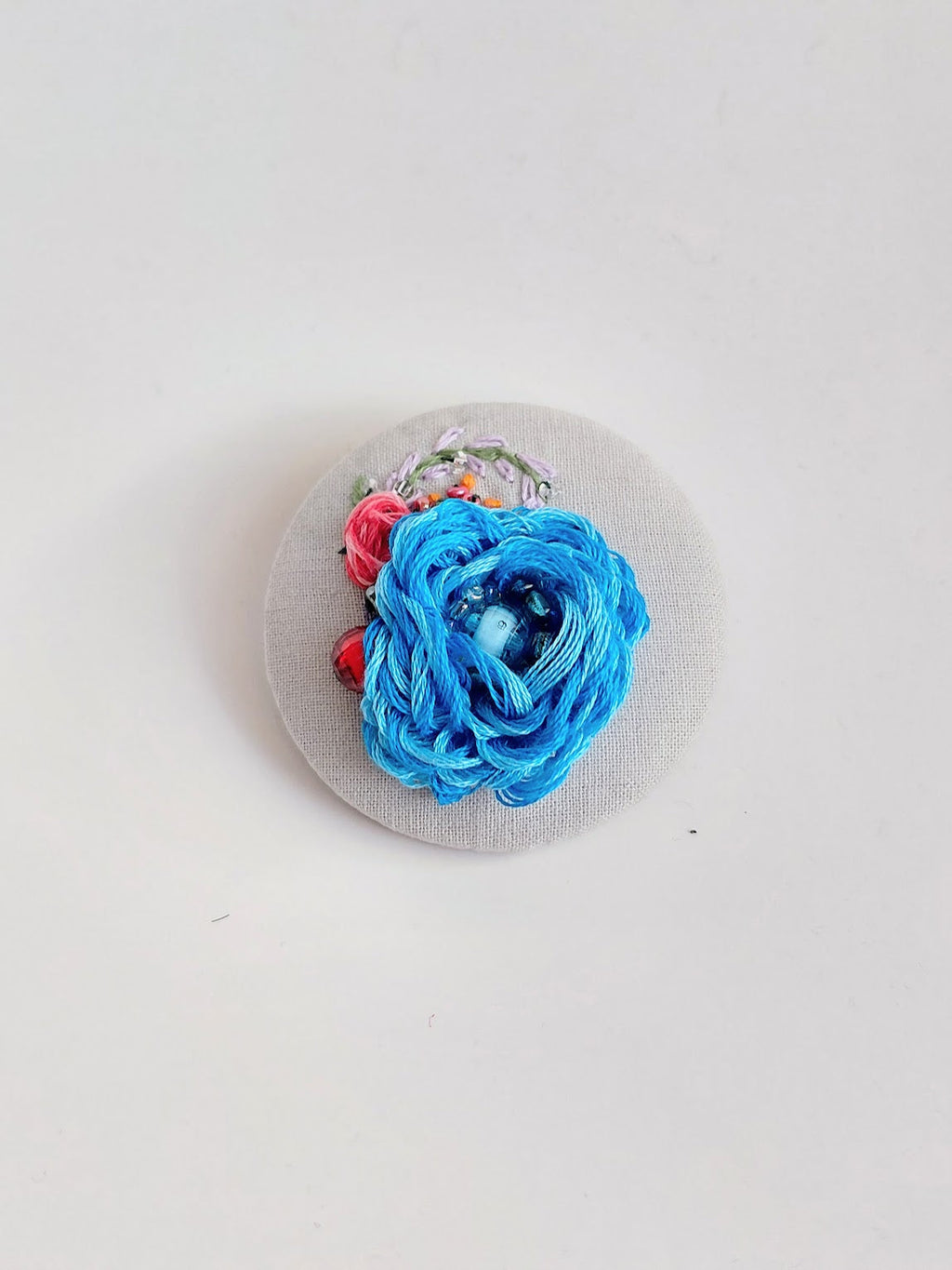 Decorative blue flower brooch on grey background
