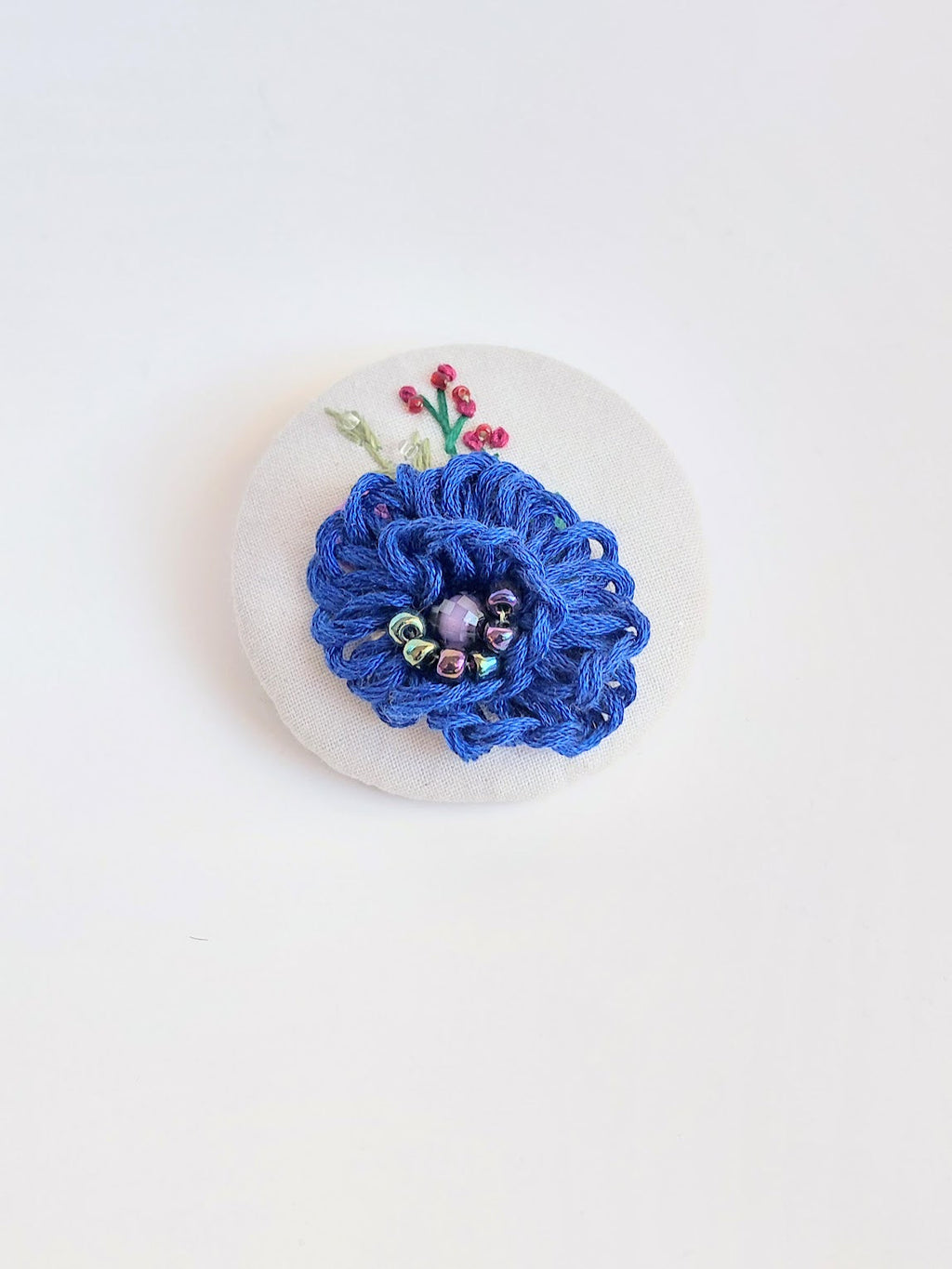 Decorative blue flower brooch on white background