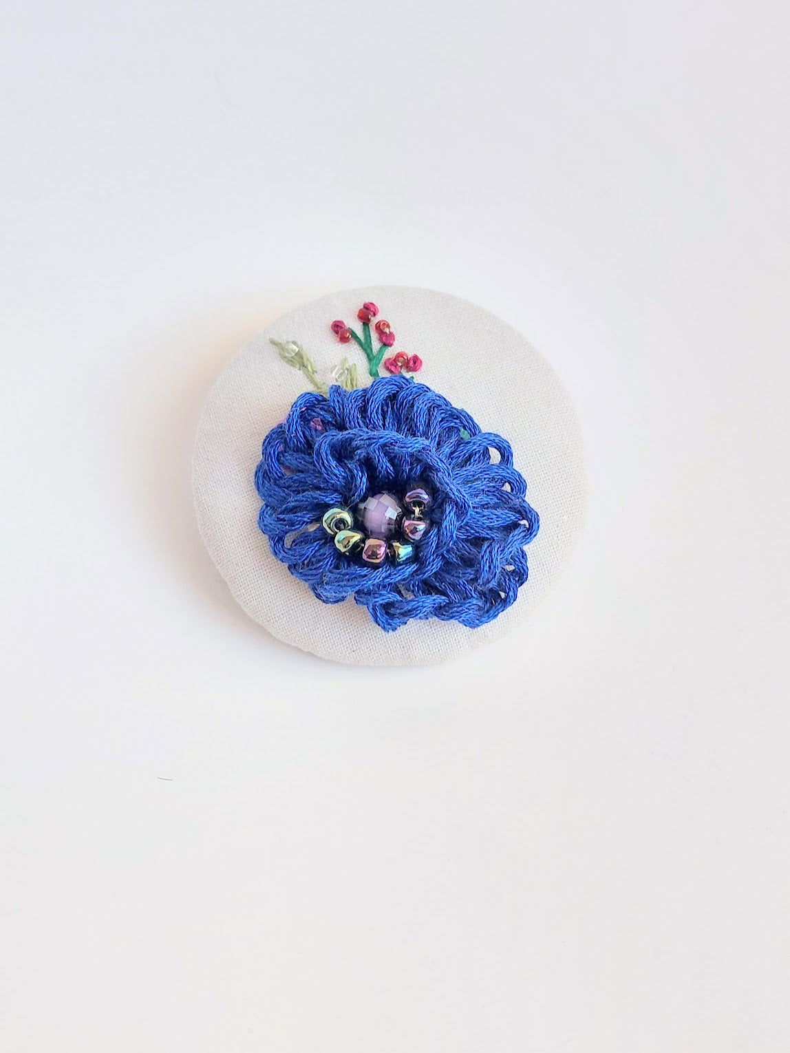 Decorative blue flower brooch on white background